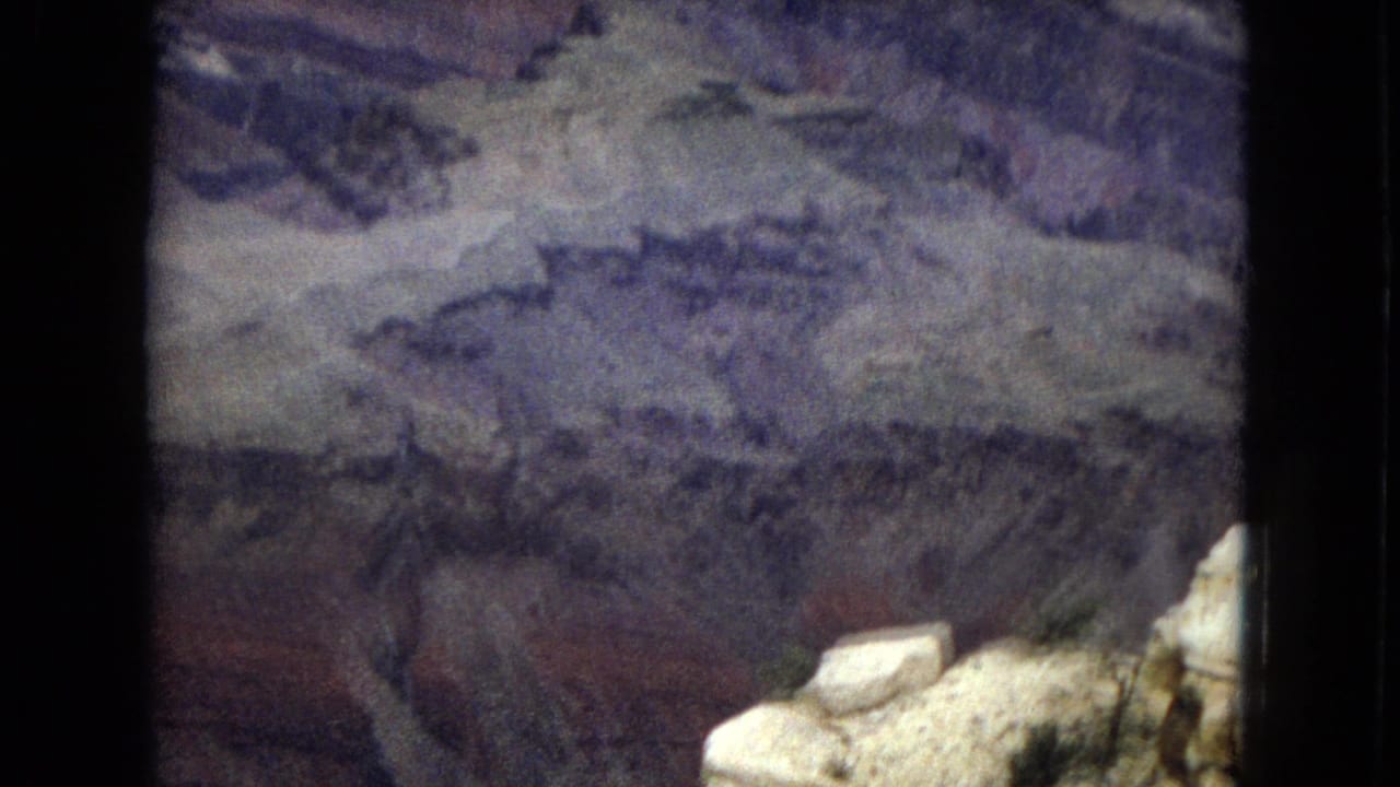 Layered canyon walls seen through a dark 8mm film frame border.
