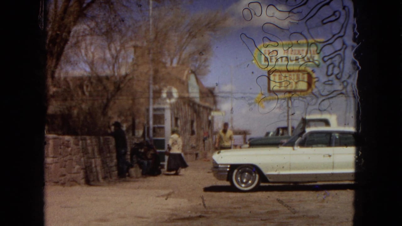 Roadside stop in Arizona showing the Gray Mountain Restaurant and Trading Post sign, a white classic car, and several people near a rustic building.