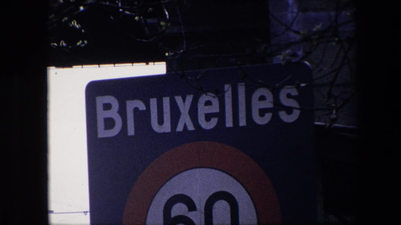 Closer 1967 Brussels view of the blue Bruxelles sign, showing large white lettering and the upper portion of the red-ringed 60 km/h speed-limit roundel.