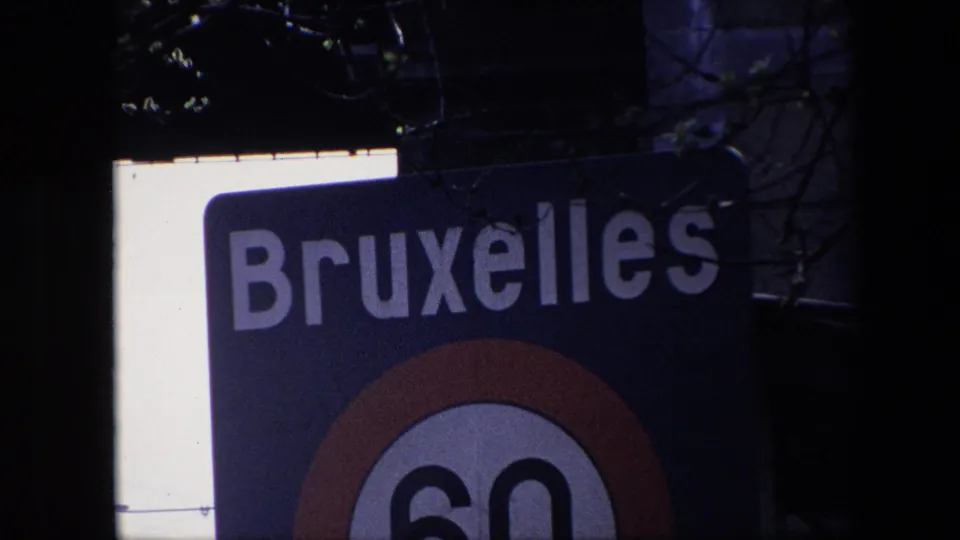 Closer 1967 Brussels view of the blue Bruxelles sign, showing large white lettering and the upper portion of the red-ringed 60 km/h speed-limit roundel.