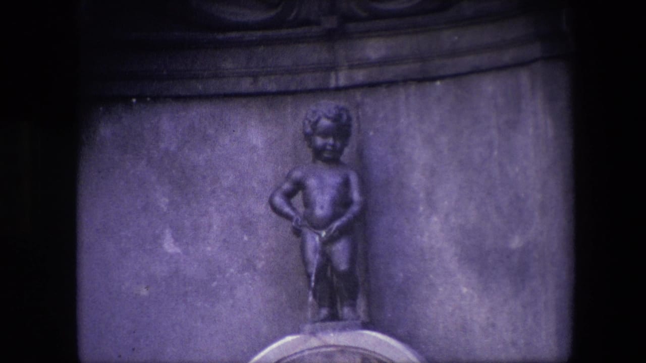 Tightly framed 1967 Brussels view of the Manneken Pis statue with the basin edge partly visible at the bottom of the 8mm frame.