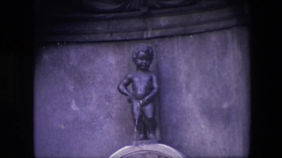 Tightly framed 1967 Brussels view of the Manneken Pis statue with the basin edge partly visible at the bottom of the 8mm frame.