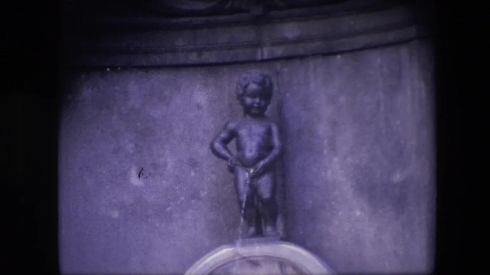 Final 1967 Brussels 8mm frame holding on the Manneken Pis fountain, with the figure centered above the basin and no visitors visible.