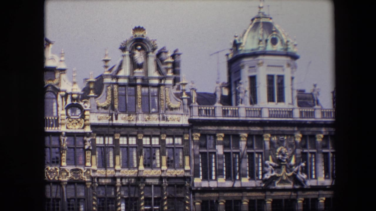 Closer view of upper stories with ornate trim, tall windows, and a domed turret.