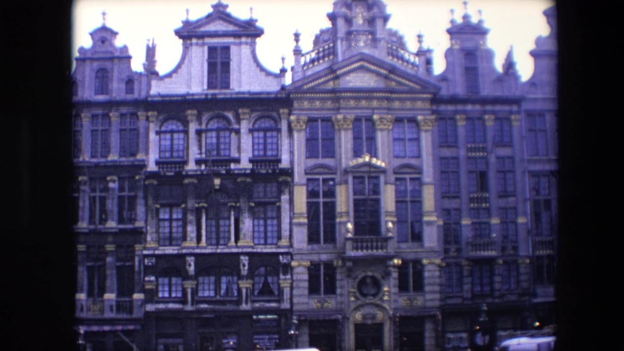 1967 Brussels home-movie frame showing ornate historic multi-story facades with gables, balconies and decorative stonework.