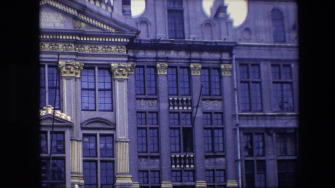 Historic facade with gold ornament, rows of windows, and partial roofline.