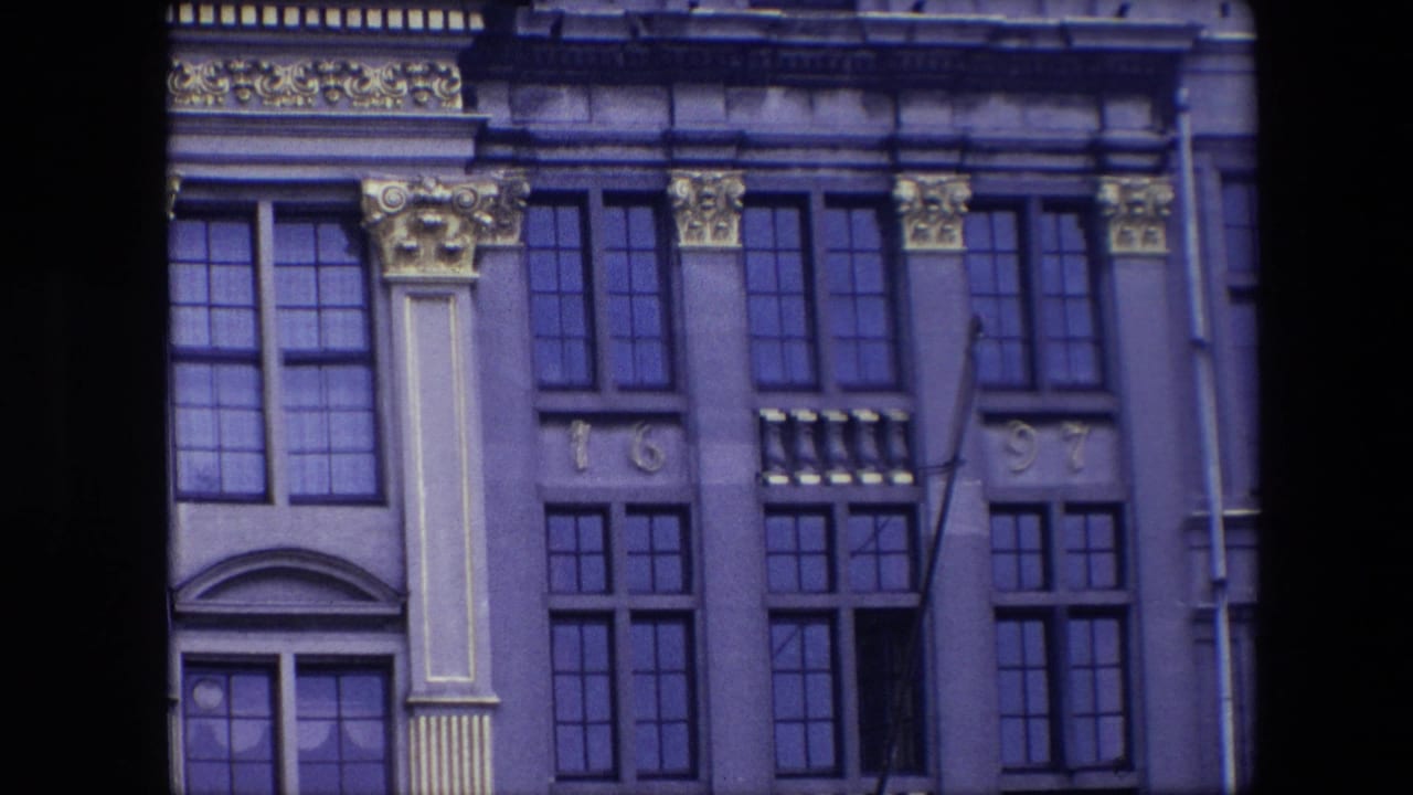 1967 Brussels 8mm frame showing a historic building facade with tall windows, decorative capitals, pilaster panels, and the numerals 16 and 97.