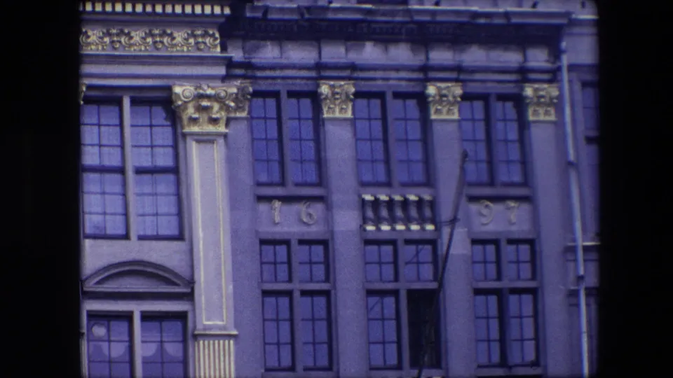 1967 Brussels 8mm frame showing a historic building facade with tall windows, decorative capitals, pilaster panels, and the numerals 16 and 97.