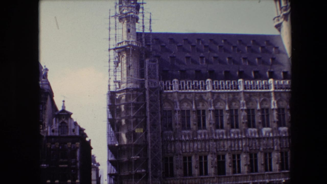 1967 Brussels exterior view of an ornate Gothic-style historic building, likely the Brussels Town Hall, with scaffolding on the tower side and a steep dark roof.