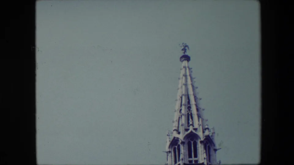 Final Brussels 1967 frame showing the Gothic-style spire low and to the right, with sky occupying most of the composition.
