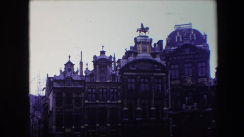 1967 Brussels 8mm still showing a slightly lower street-level view of the ornate facade, including gables, rows of windows, lamps, and the horse statue on the roof.