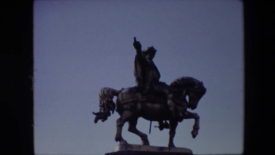 The same Brussels equestrian statue appears against a clearer blue sky, with the rider and horse silhouetted by the 8mm exposure.