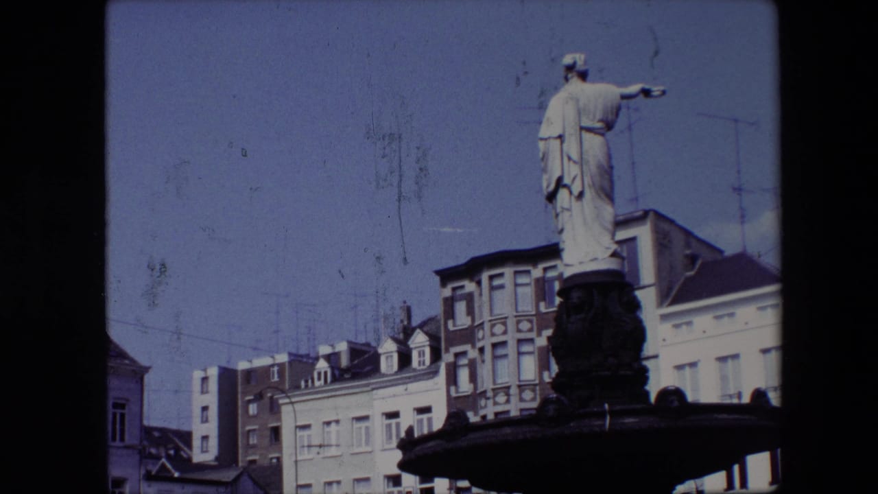 1967 Brussels frame with the statue higher in the composition, pointing across the square above pale and brick building facades.