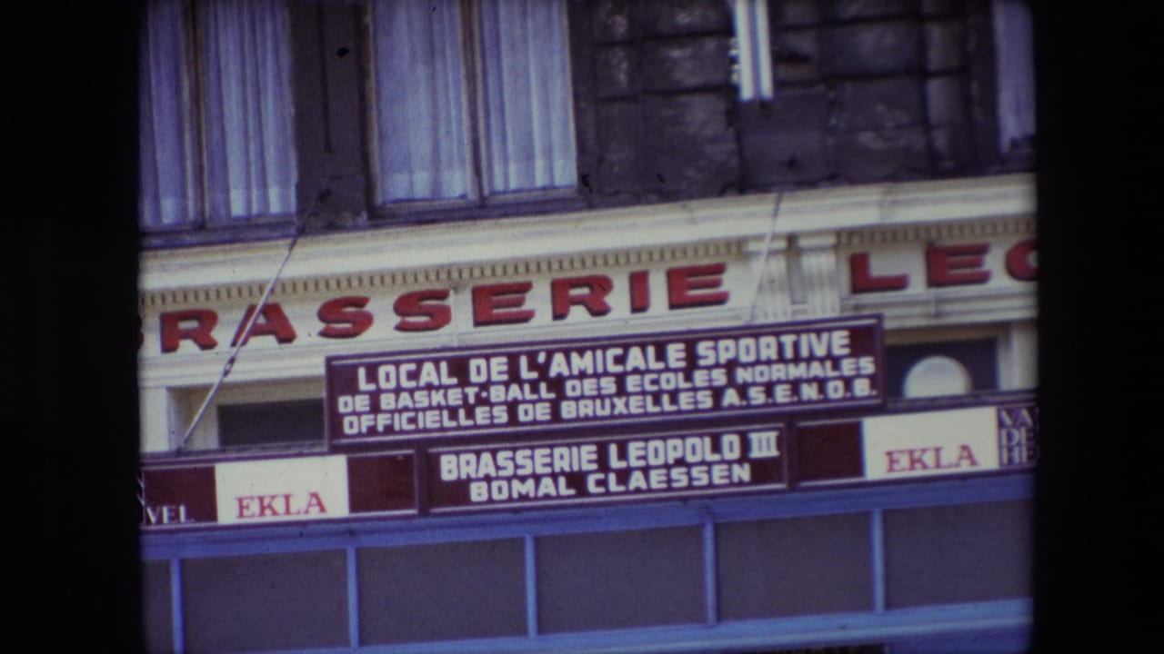1967 Calais brasserie storefront with large red facade lettering, a readable French sports association sign, EKLA advertising, upper-story windows, and blue lower storefront framing.