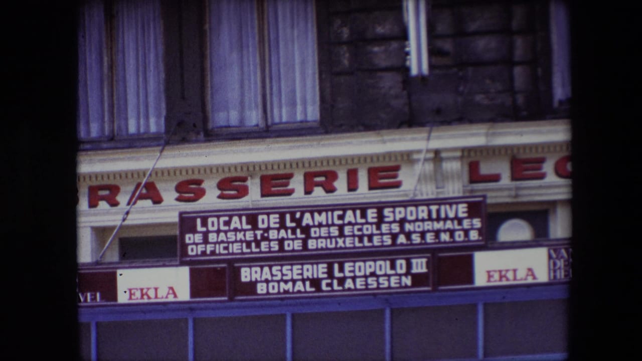1967 8mm travel frame showing a European brasserie exterior with a French-language sign for a Brussels school basketball sports association and Ekla beer branding.