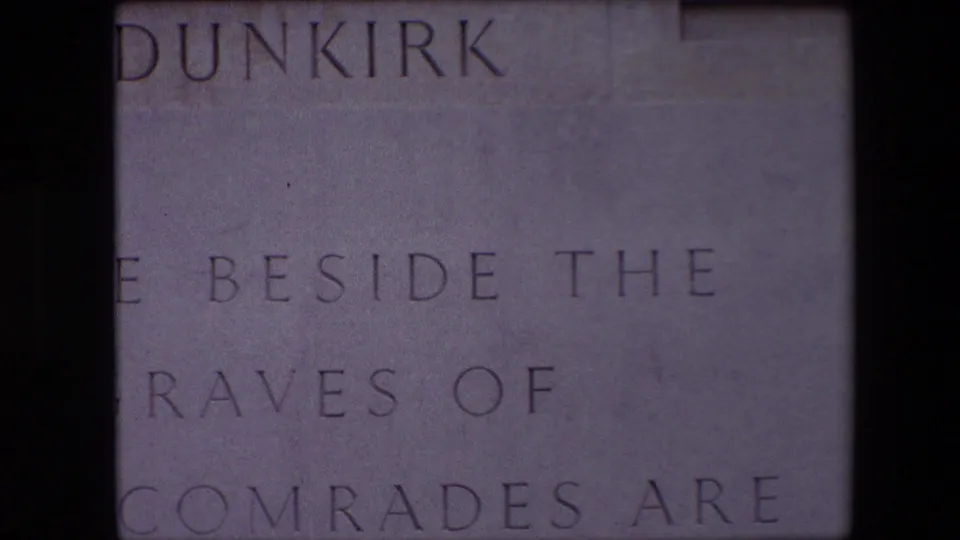 1967 8mm close-up from the Dunkirk memorial showing cropped engraved wording on pale stone, including parts of “BESIDE THE,” “GRAVES OF,” and “COMRADES ARE.”