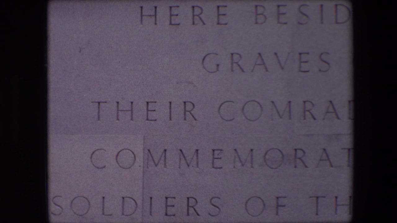 Close 1967 8mm view in Calais of pale stone blocks engraved with partial English memorial text mentioning graves, comrades, and soldiers.