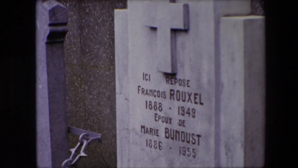 1967 Calais 8mm frame showing a cemetery gravestone with a raised cross and engraved names for François Rouxel and Marie Bunoust.