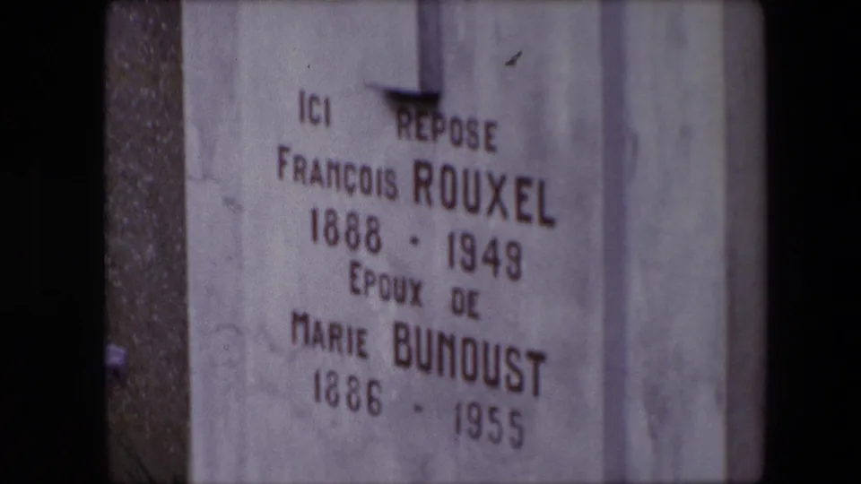 Close 8mm view in Calais, France, of the grave text reading Ici repose, François Rouxel, and Marie Bunoust with dates below.