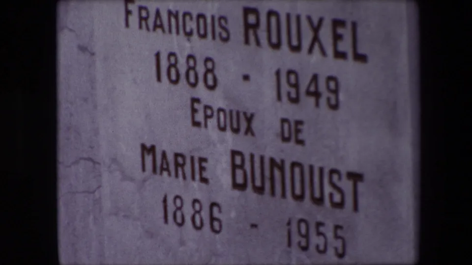 Tight Calais cemetery close-up showing the engraved names François Rouxel and Marie Bunoust with dates on a pale stone marker.
