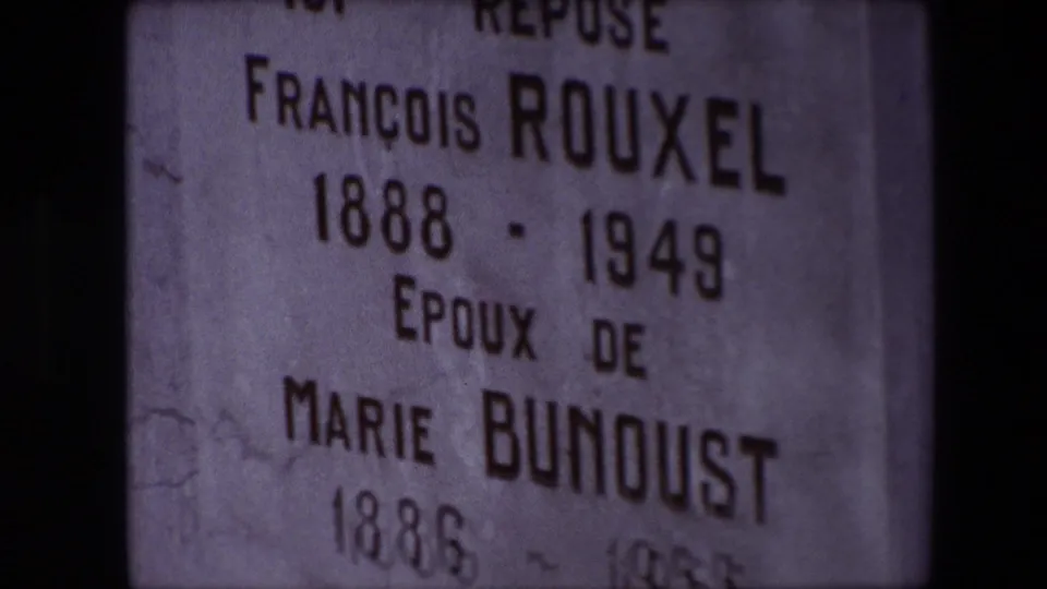 Close view of the same Calais grave marker, with the inscription for François Rouxel and Marie Bunoust partly cropped by the home-movie framing.