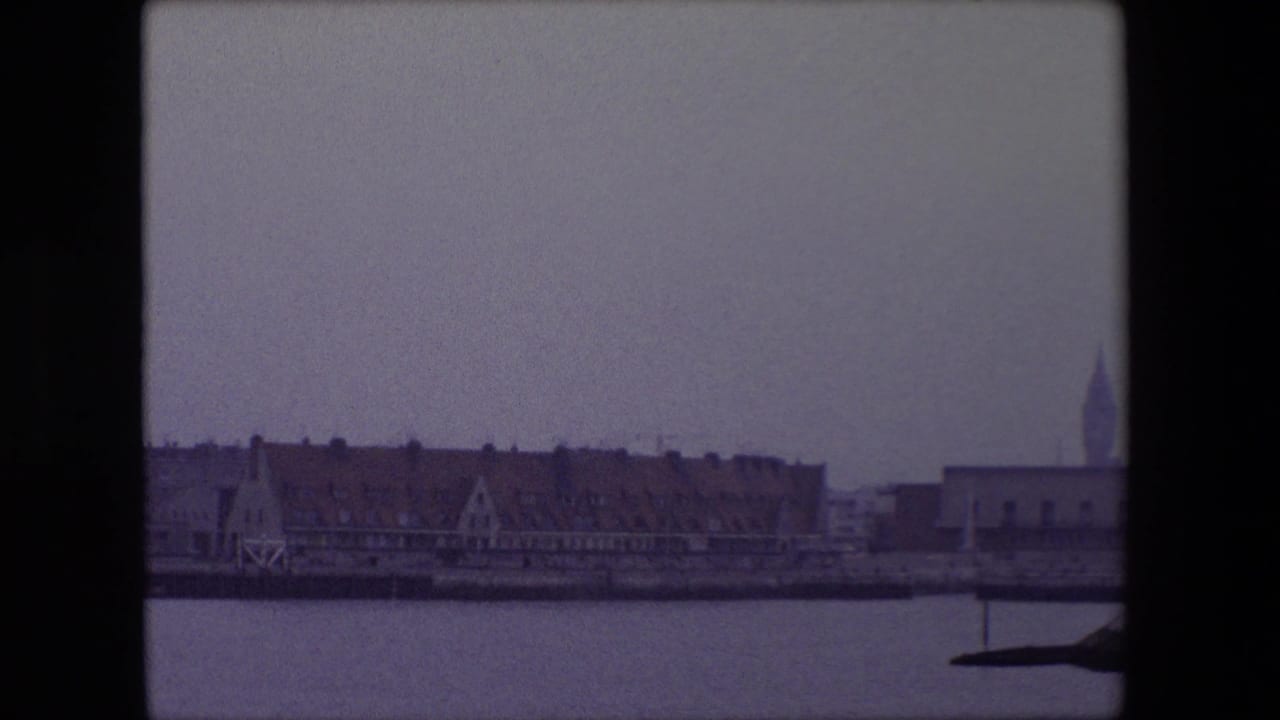 Harbor town buildings with a church steeple visible at the right edge.
