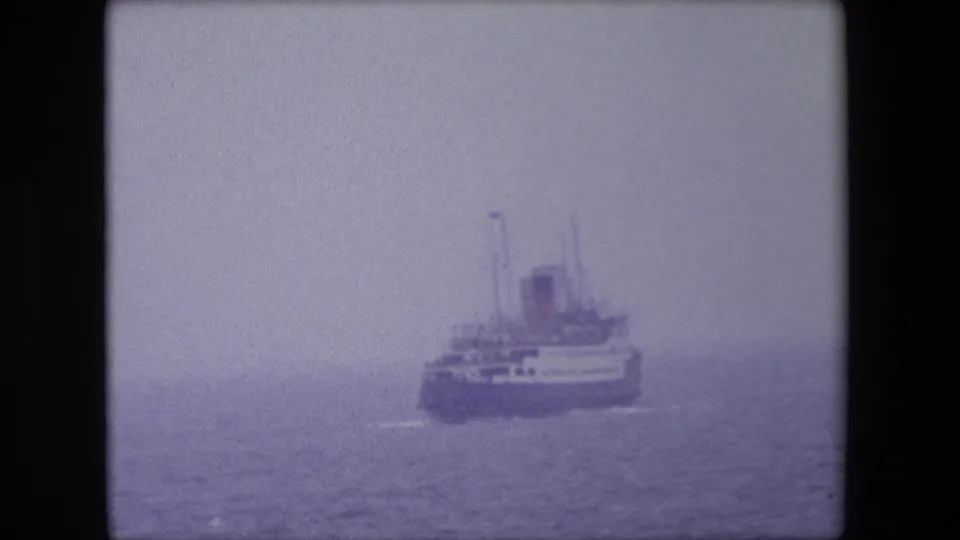 1967 Calais maritime frame showing a large passenger ship or ferry softened by fog as it moves across calm water.