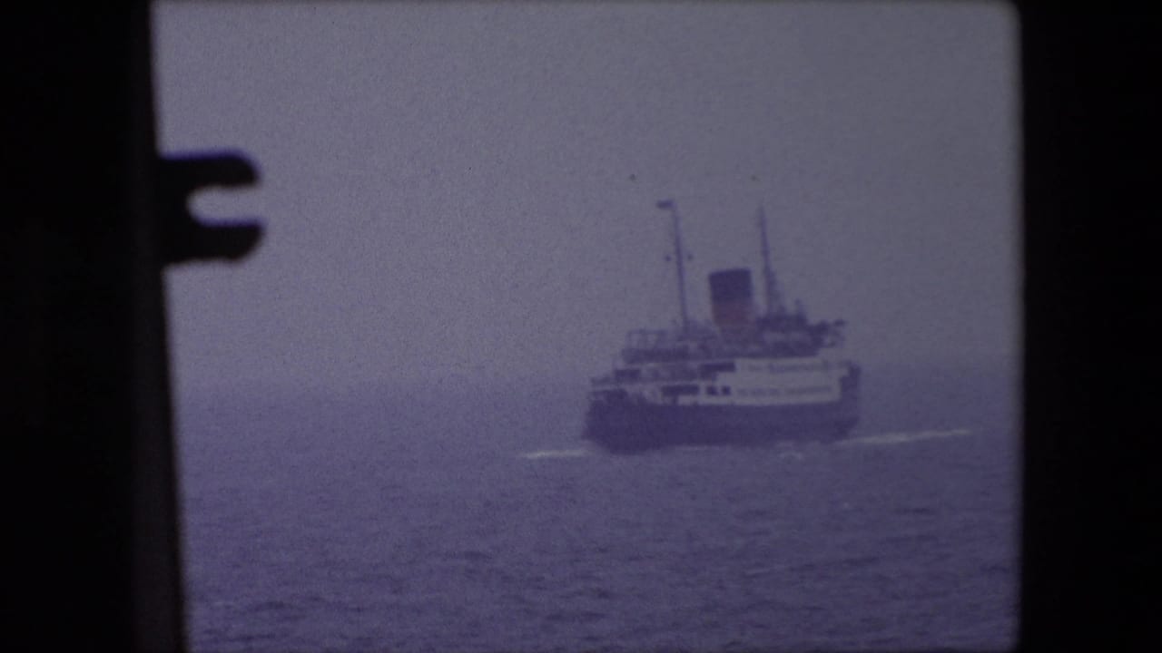 Distant passenger ship off Calais, France in 1967 appears through dark foreground frame edges on a hazy sea.