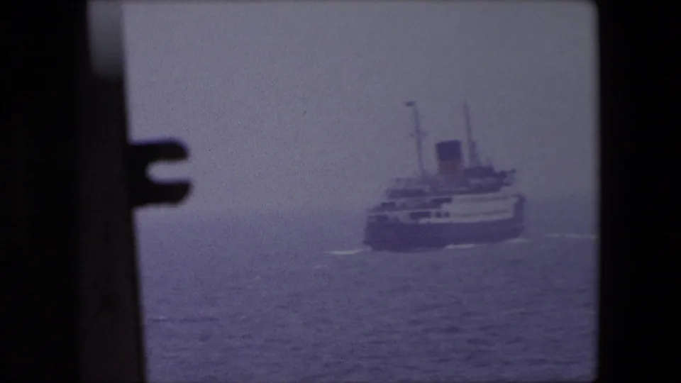 A large passenger ship near Calais in 1967 is seen from a hazy frontal angle, with dark foreground framing and muted sea tones.