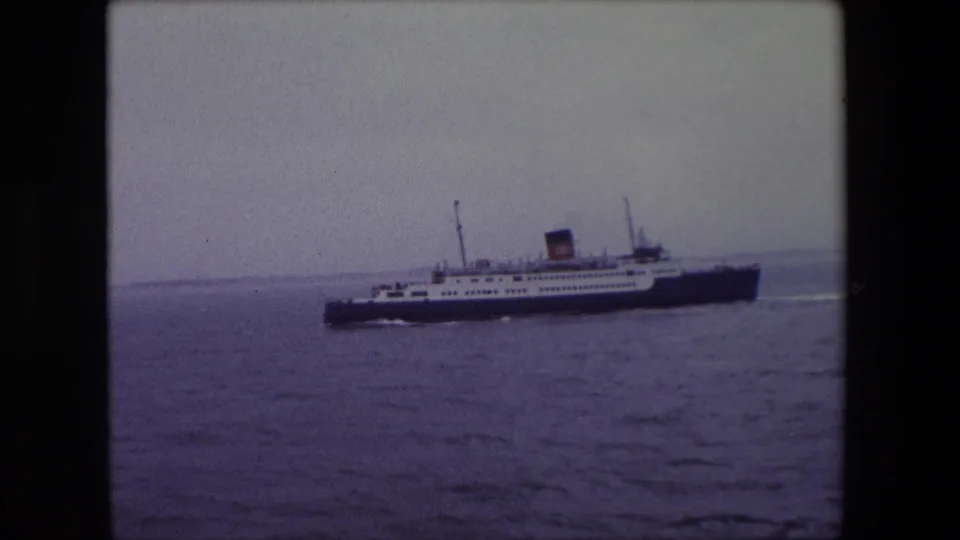 A clearer side profile shows the large passenger ship crossing the water near Calais, France, in 1967 under a pale overcast sky.
