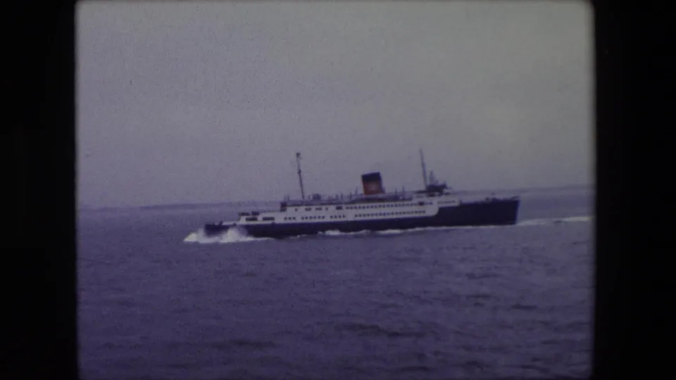 The passenger ship continues in side profile near Calais in 1967, leaving a bright white wake across the muted blue-gray sea.