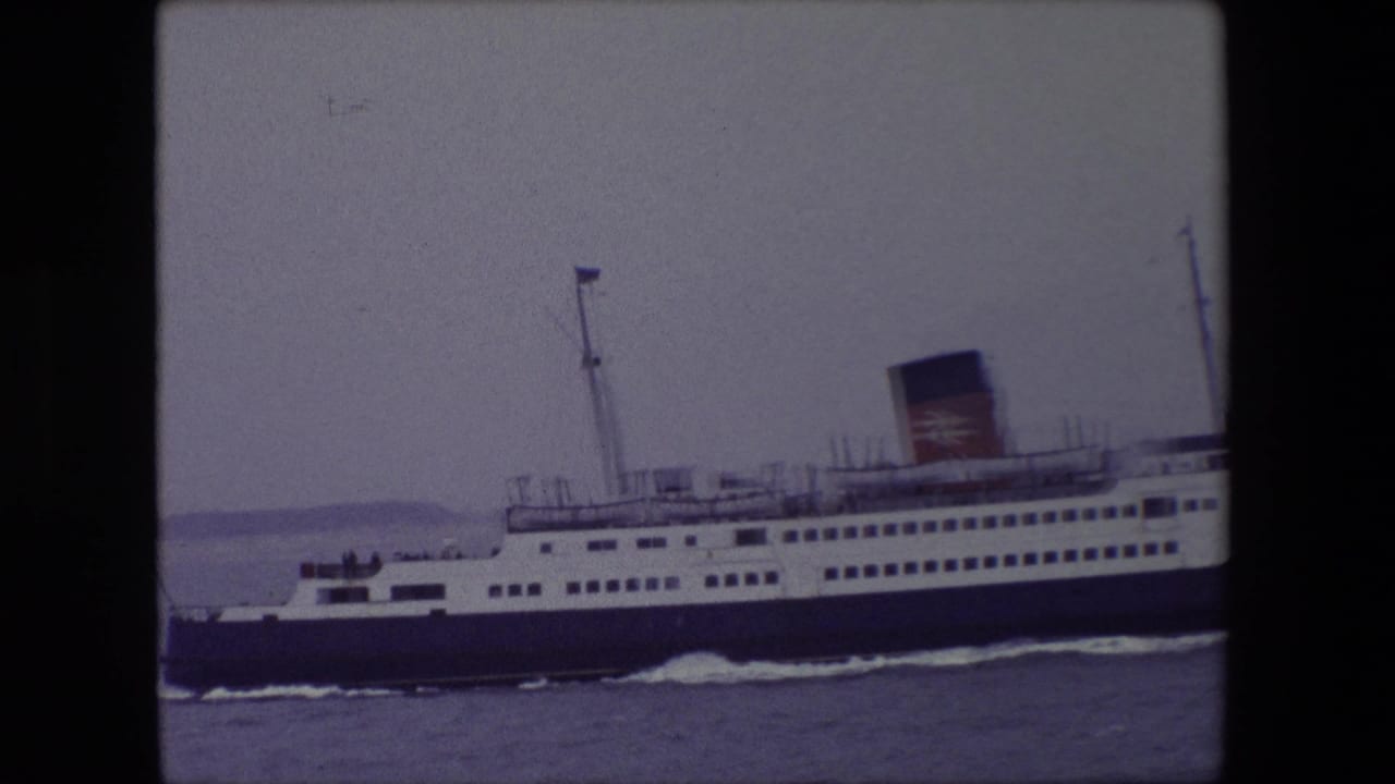 Side view of a passenger ferry passing through calm water.