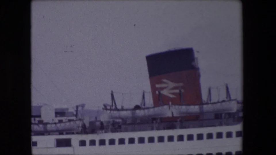 1967 Calais ferry view showing the ship side, deck equipment, and a red-and-black funnel bearing the British Rail logo under overcast light.