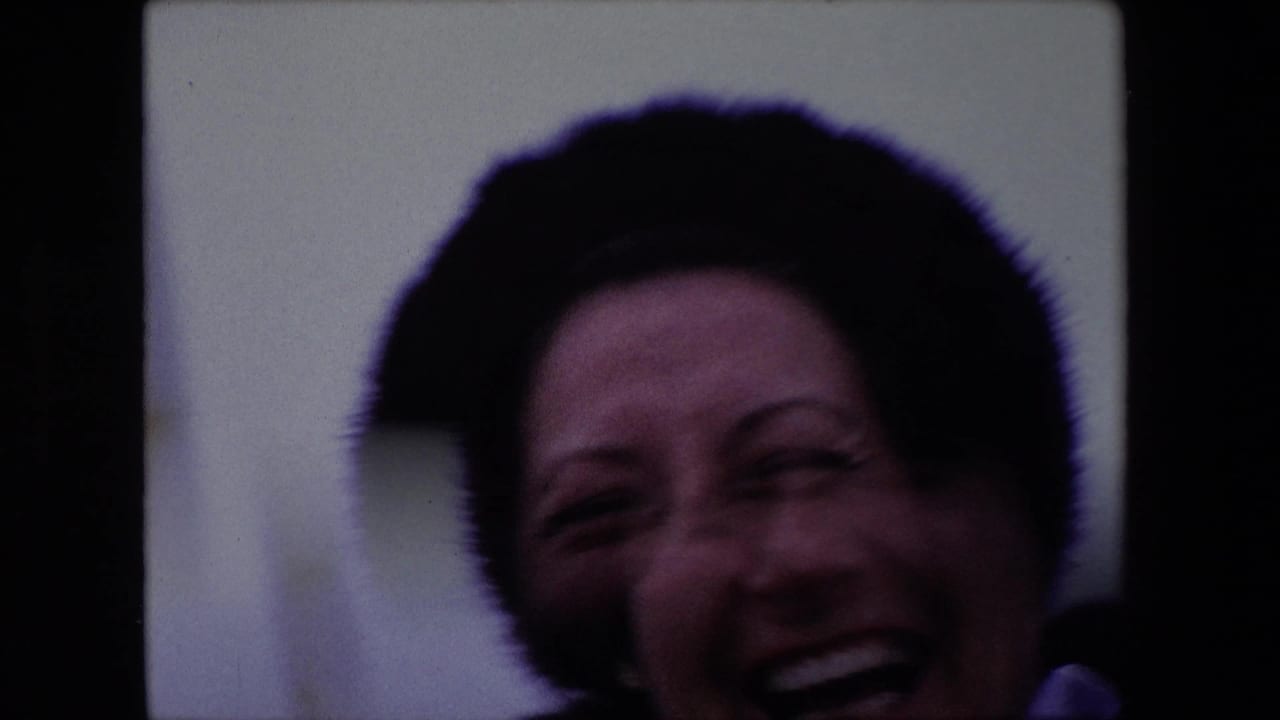 Close view of a laughing woman in a dark fur hat, partly cropped.
