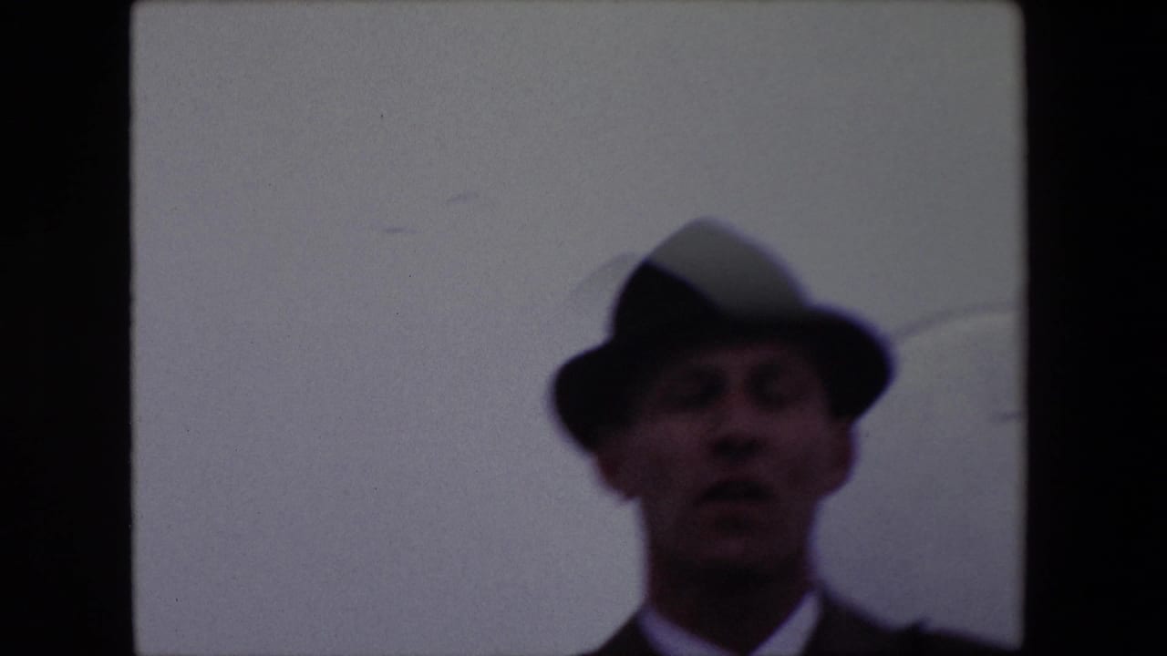 Soft-focused man in a fedora near the right side of the frame.