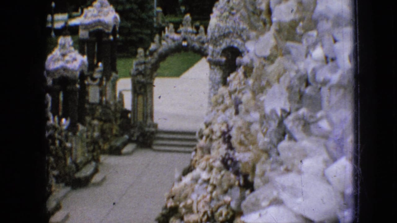 Ornate stone arches and steps seen beside a shell-covered wall.