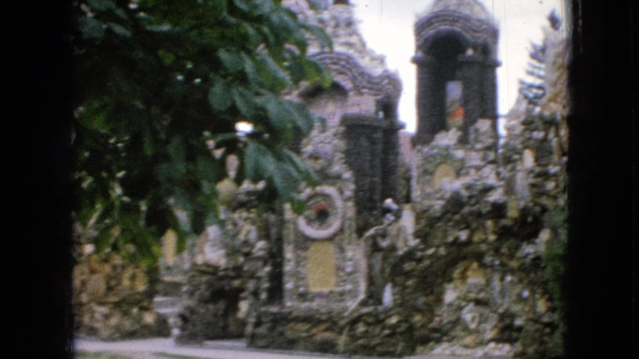 Ornate stone structures with a tower-like arch, circular ornament, and overhanging leaves.