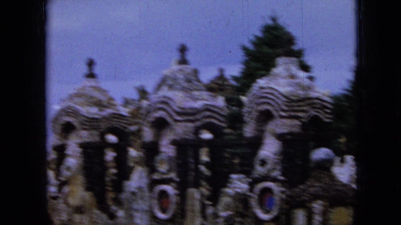 Ornate stone landmark with domes, arches, crosses, and trees behind it.