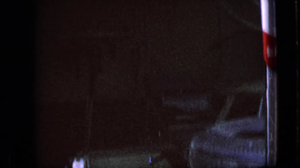 The final frame shows the dark garage interior with the man mostly obscured and machinery or equipment partly visible, preserving the low-light 8mm texture of the 1967 Iowa scene.
