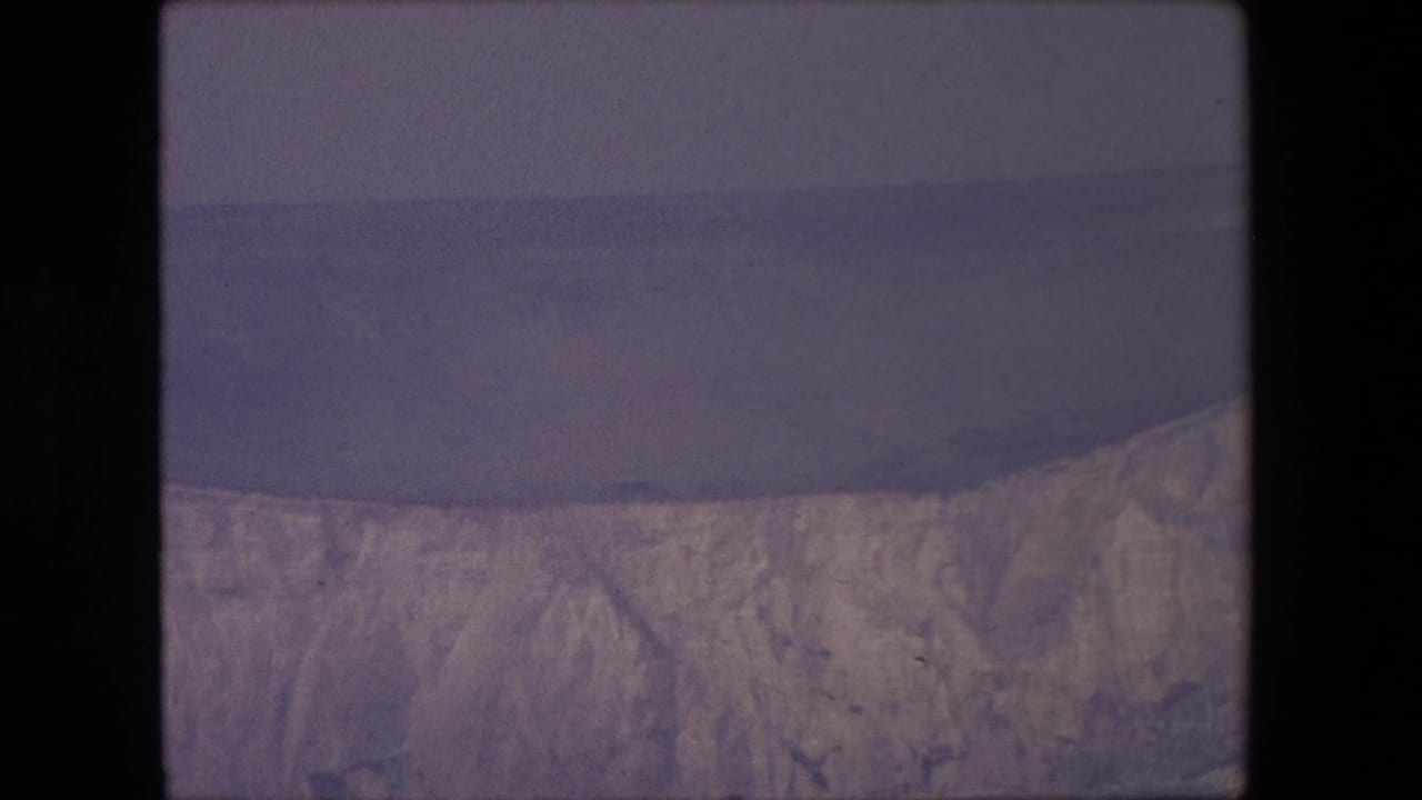 Pale chalk cliffs above a dark sea under an overcast sky.