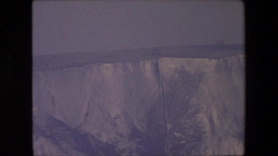 Faded 8mm frame, attributed by metadata to London in 1967, showing the lower portion of a rocky eroded bank beneath a horizontal ledge.