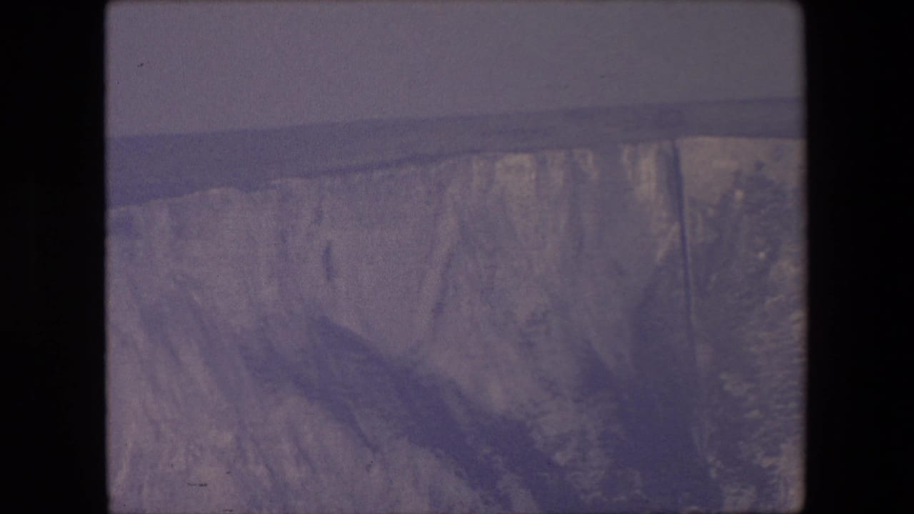 Glacier face above water with dark film borders.