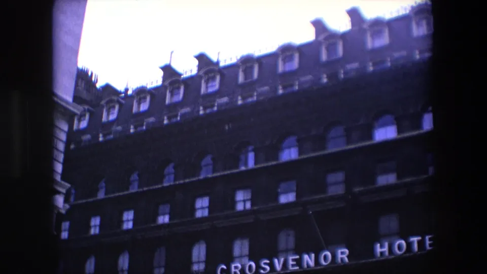 1967 London hotel exterior seen from a low angle, with the Grosvenor Hotel sign partly visible below rows of windows and roof dormers.