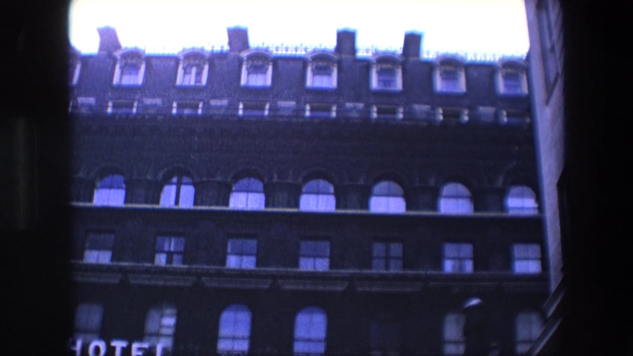 Dark hotel building viewed from below with rows of windows and a partial HOTEL sign.