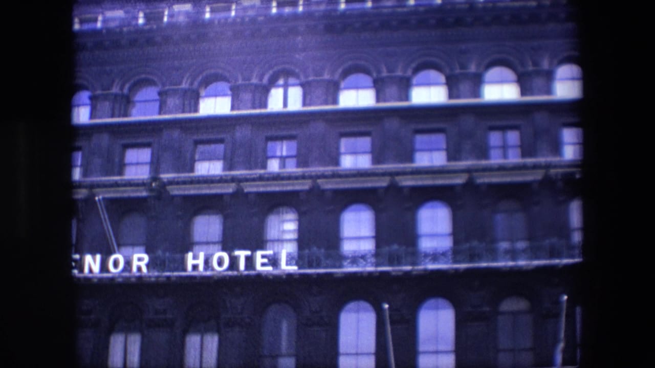 Brick hotel facade with arched windows and partial GROSVENOR HOTEL sign.