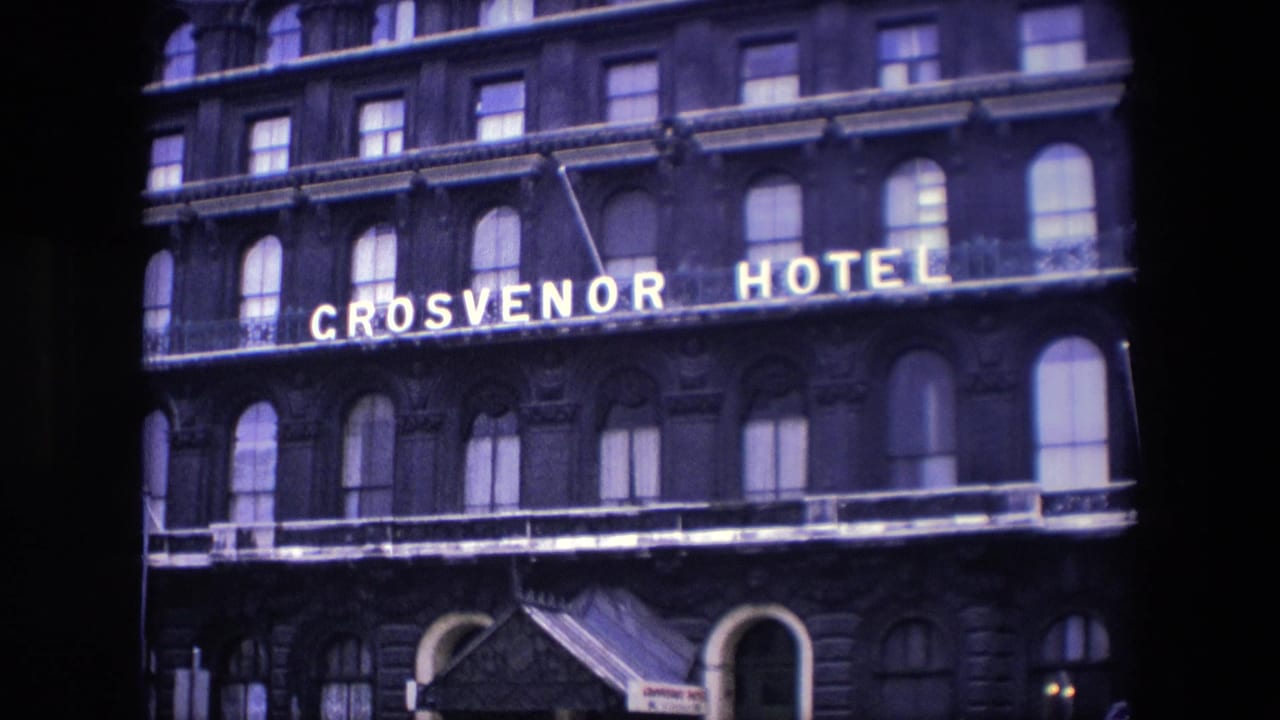Grosvenor Hotel facade with illuminated sign, windows, and entrance beginning to appear below.