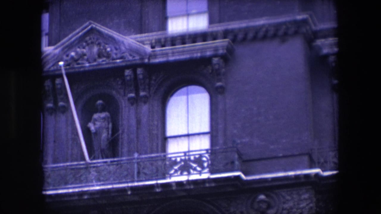 Ornate stone facade with a curtained arched window and statue niche.