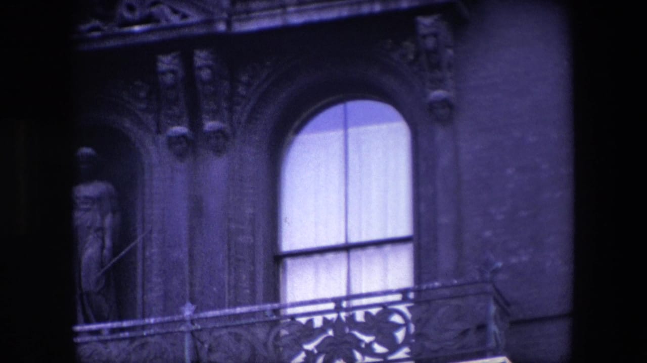 Closer view of a curtained arched window beside carved stonework and a statue niche.