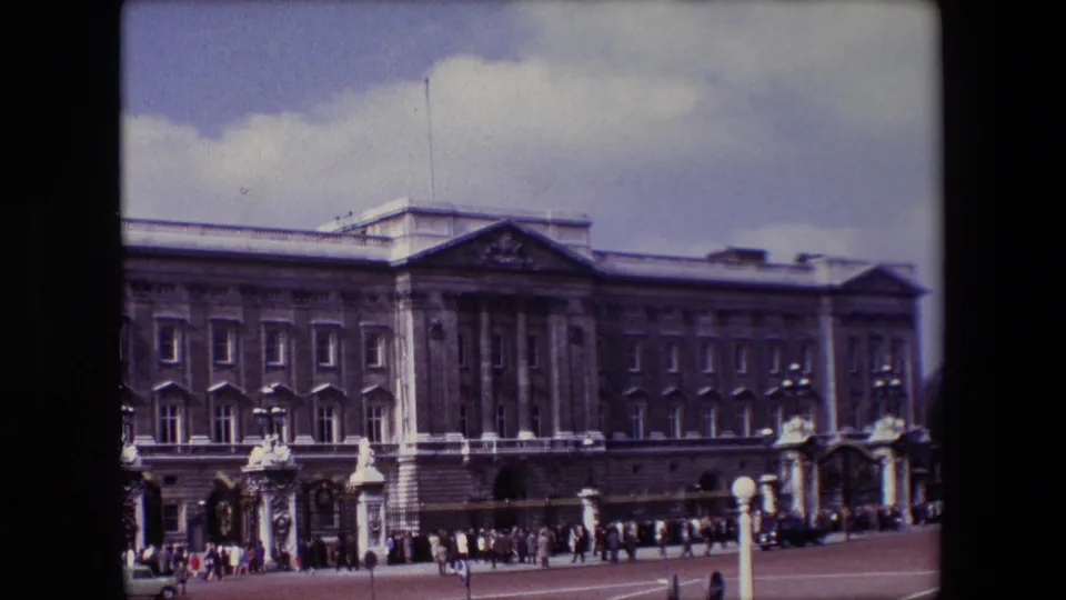 The final 1967 8mm frame holds on Buckingham Palace in London, showing the main facade, palace gates, and tourists dispersed across the forecourt.