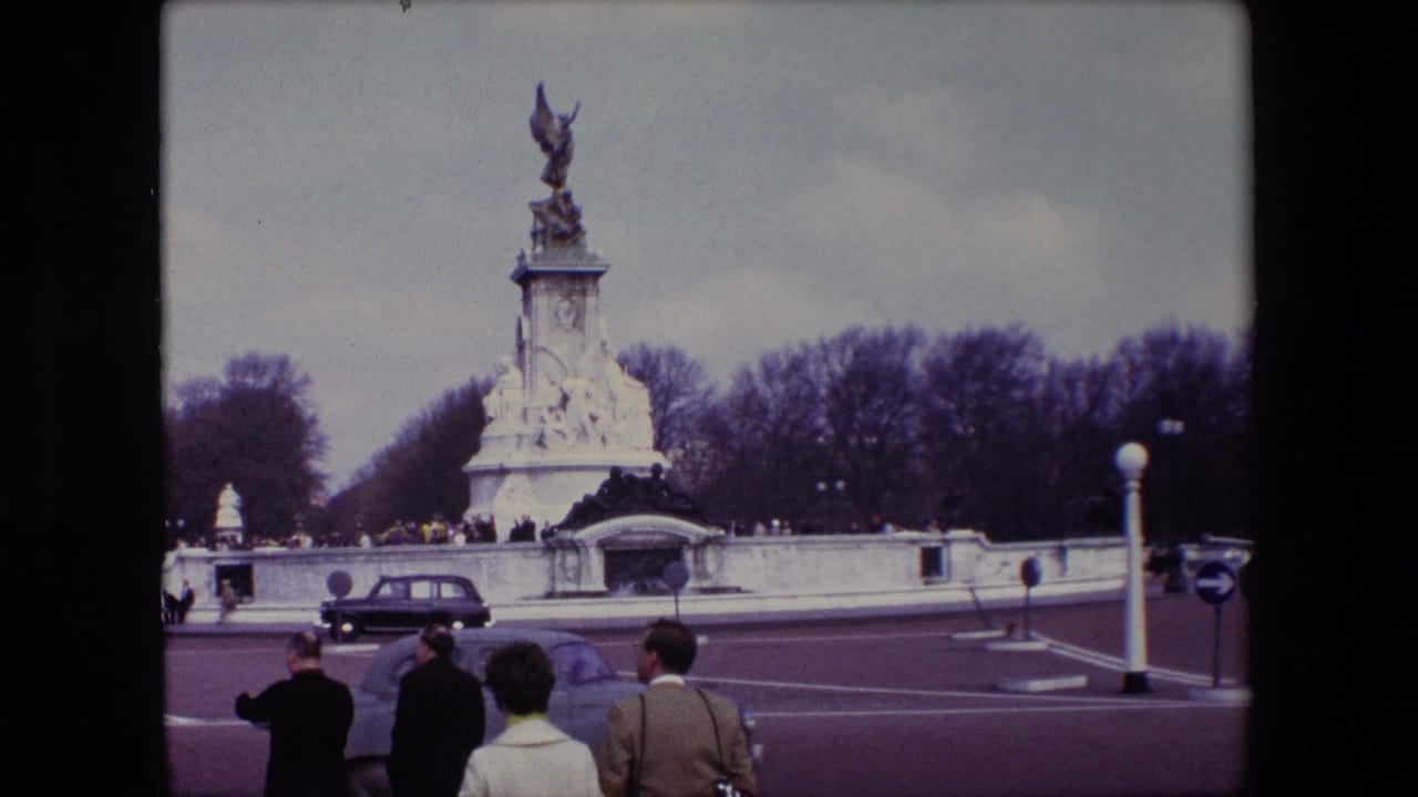 Victoria Memorial seen across a roadway with pedestrians and a classic car in the foreground.